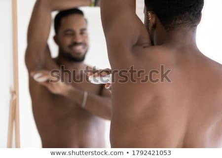 Stok fotoğraf: Young Man Applying Deodorant