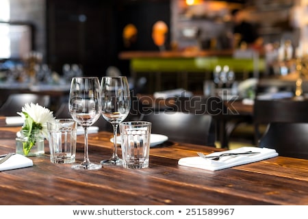 ストックフォト: Glasses Flowers Fork Knife Served For Dinner In Restaurant With Cozy Interior