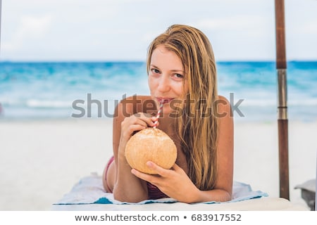 Stock fotó: Young Woman Drinking Coconut Milk On Chaise Longue On Beach