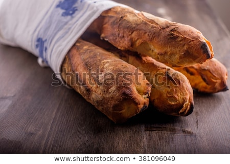 Сток-фото: Fresh Baked Baugetts Lined In A Kitchen Towel