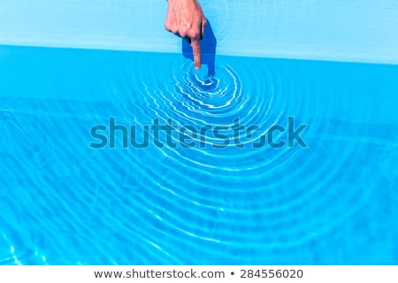 Stockfoto: Forefinger Making Waves As Circles In Swimming Pool