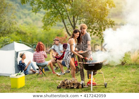 Stock fotó: Young Man Placing Meat On Barbecue