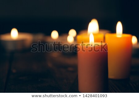 Foto stock: Candle Burning In Darkness Over Black Background