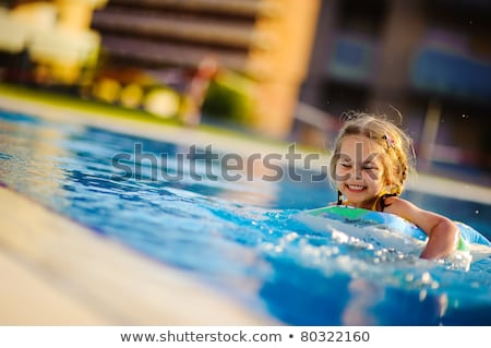 ストックフォト: Pretty Little Girl Swimming In Outdoor Pool And Have A Fun With Inflatable Circle