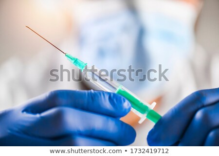 Stock photo: Medical Plastic Syringe With A Needle Filled With Liquid On Blue