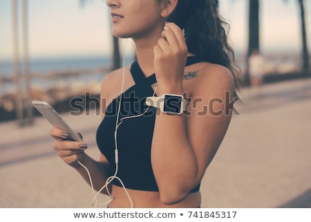 Stock photo: Image Of Aerobic Woman Holding Smartphone And Listening To Music