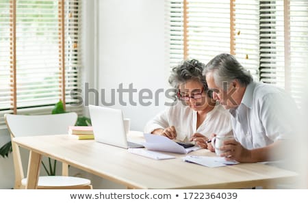 Stok fotoğraf: Worried Senior Couple Using Laptop At Home