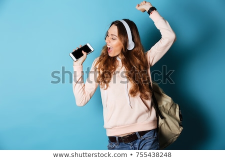 Foto stock: Smiling Girl With Smartphone And Headphones