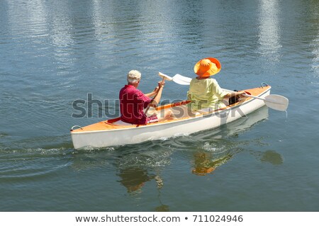 Foto stock: Older Couple Rowing Canoe On Lake
