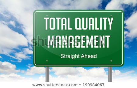 Stockfoto: Total Quality Management On Green Highway Signpost