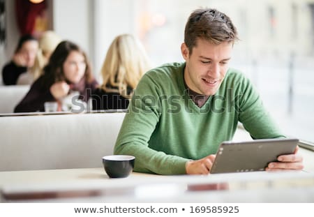 Stock foto: Young Man With A Coffee Using A Tablet Computer