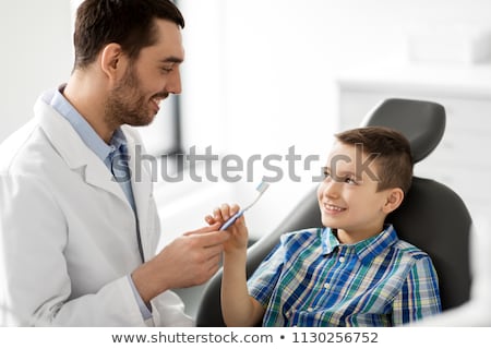 Stockfoto: Dentist Giving Toothbrush To Kid Patient At Clinic