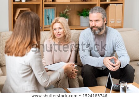[[stock_photo]]: Mature Man And His Wife Sitting On Sofa And Consulting With Real Estate Agent