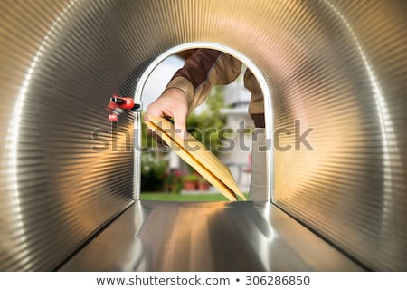 Stok fotoğraf: Postman Putting Mail In Mailbox