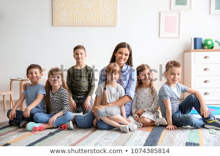 Foto stock: Portrait Of Group Of Primary Schoolchildren And Teachers Sitting