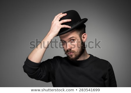 [[stock_photo]]: Young Man Raising His Hat In Respect And Admiration For Someone