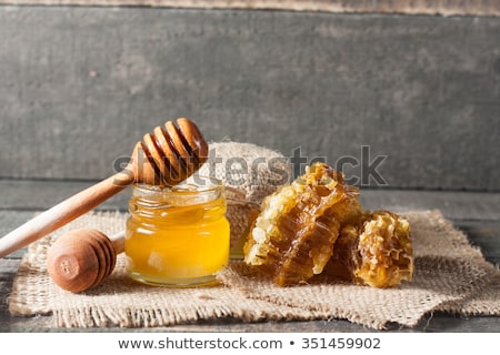 Stockfoto: Organic Honey Drips From Wooden Dipper In Jar