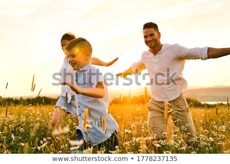 Stockfoto: Happy Family Having Fun On Daisy Field At Sunset