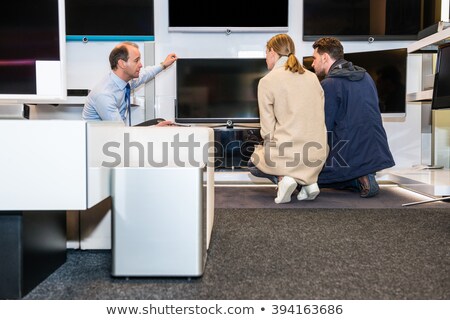 Foto stock: Salesman Showing Latest Flat Screen Tv To Couple