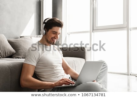 Stockfoto: Bearded Man 30s In Basic Clothing Sitting On Floor At Home And