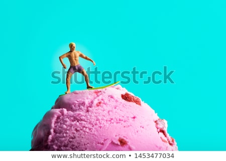 Foto stock: Miniature People Surfing On An Ice Cream Ball