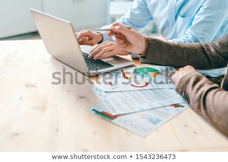 Foto d'archivio: Two Modern Business Analysts Discussing Ideas For Presentation On Laptop Display