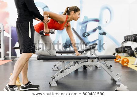 Stok fotoğraf: Young Male Trainer Giving Instructions To A Woman In A Gym