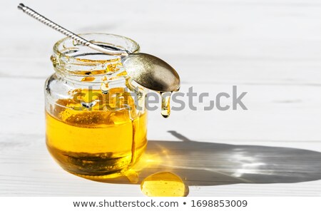 Foto stock: Macro Close Up Honey Background With Natural Flower Yellow Dessert In Glass Pot With Wooden Dipper