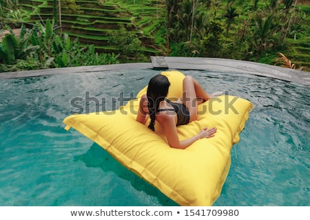 Stockfoto: Enjoying Suntan Vacation Concept Top View Of Slim Young Woman In Bikini On The Blue Air Mattress I