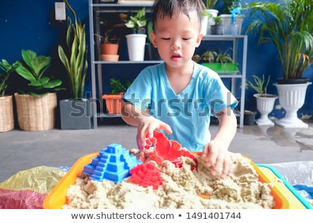 Foto stock: Toddler Boy Playing With Sand On The Beach Development Of Fine Motor Skills