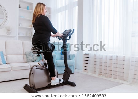 ストックフォト: Overweight Woman Exercising On Bike