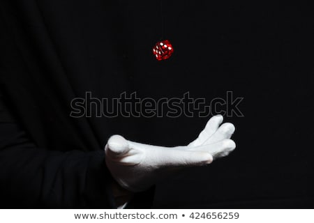 Foto stock: Hand Of Magician In White Glove Showing Tricks With Dice