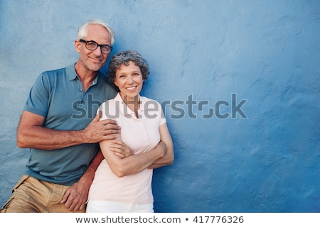 [[stock_photo]]: Portrait Of Couple Standing Against Wall