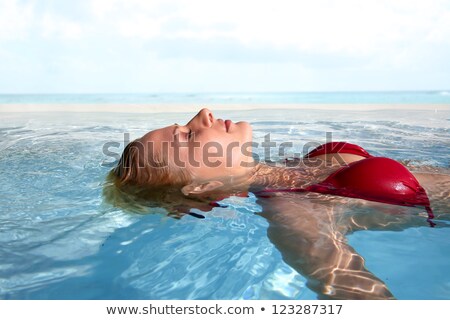 Foto stock: Peaceful Blonde Floating In The Pool