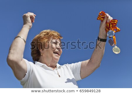 Stockfoto: Older Woman Cheering With Medals