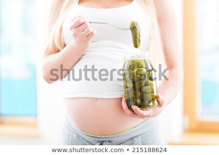 Stockfoto: Pregnant Woman Eating Pickle From Jar