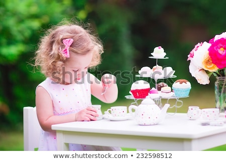 Stockfoto: Little Girl Playing With Toy Tea Set At Home