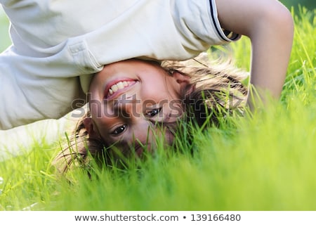 ストックフォト: Portraits Of Happy Kids Playing Upside Down Outdoors In Summer Park Walking On Hands