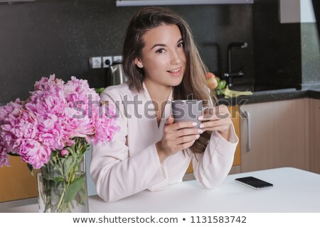 Foto stock: Happy Attractive Young Woman In Grey Bathrobe Drinking Milk