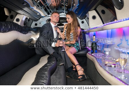 Foto stock: Young Woman Adjusting Tie Of Boyfriend In Limousine