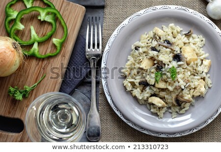 Stockfoto: Risotto With Mushrooms And Chicken On A White Plate On A Wooden