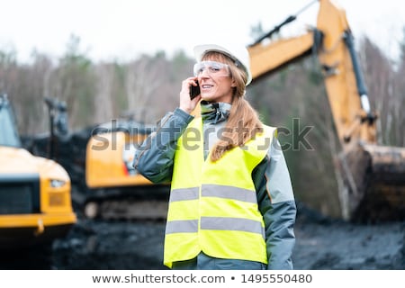 Stockfoto: Worker Woman In Open Cast Mining Using Phone