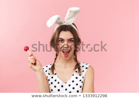 Stok fotoğraf: Pretty Young Girl With Rabbit Ears Holding Lollipop