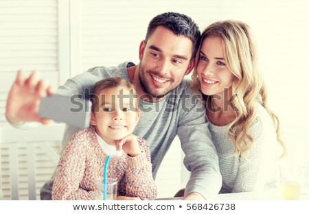 Stock photo: Mother Picturing Father With Baby By Smartphone