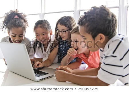 Foto stock: Group Of Curious Children Watching Stuff On The Laptop Screen
