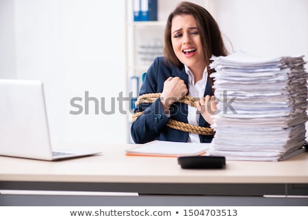 Stok fotoğraf: The Young Beautiful Employee Tied Up With Rope In The Office