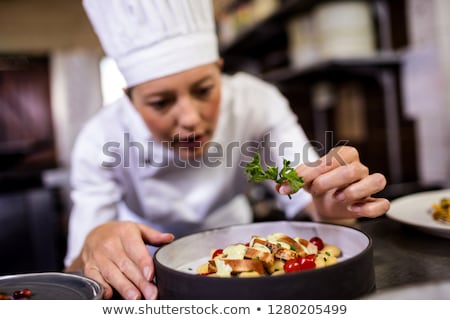 Stockfoto: Female Chef Garnishing Delicious Desserts In A Plate At Hotel