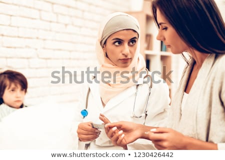 Foto stock: Muslim Female Doctor In Hospital Giving An Injection To A Little Boy