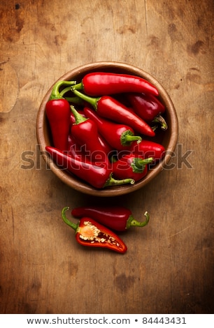 Foto stock: Hot Chilli Peppers In A Bowl Over A Wooden Table