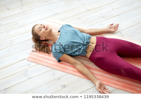 Stockfoto: Woman Doing Yoga Corpse Pose At Studio